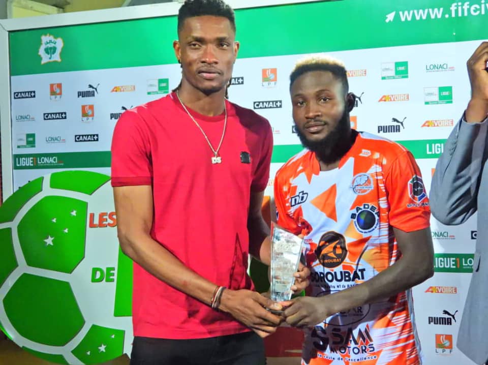 Deli Simon qui remet le trophée A+Ivoire à Cheick Ahmadou